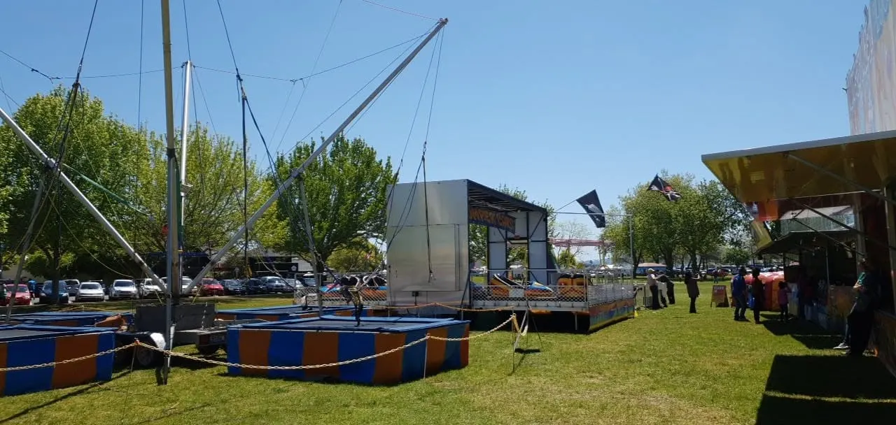 Bungy trampoline frames set up on a park lawn on a sunny day