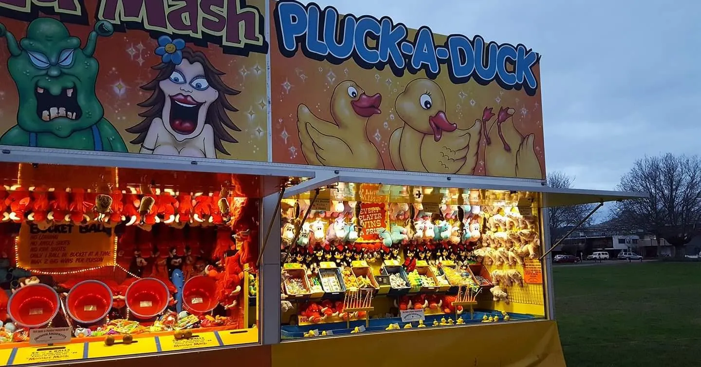 Brightly painted game stall stacked with prizes