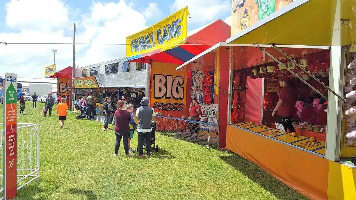 Family game stalls with big prize banners on a sunny day