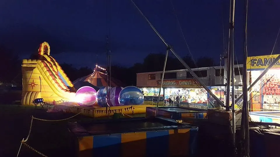 Inflatable slide and water balls glowing at dusk