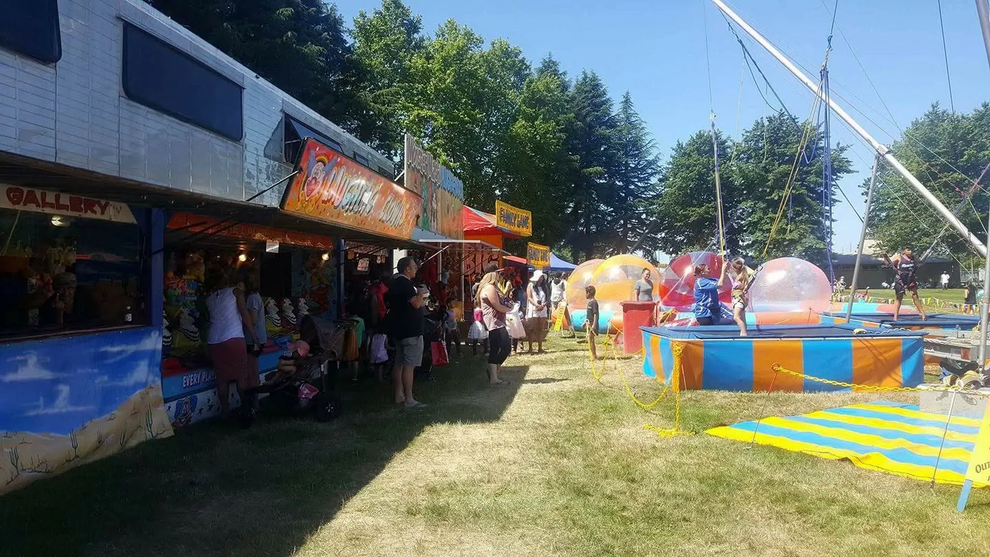 Row of colourful game stalls with water balls in the distance