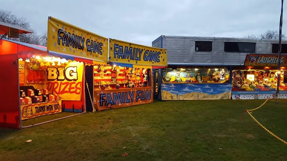 Family game stalls glowing at dusk
