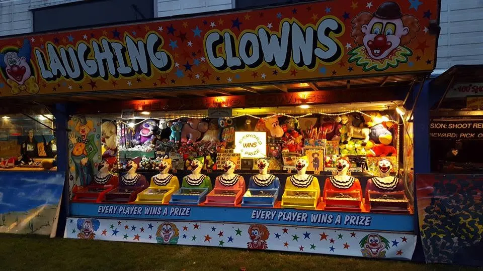 Clown-faced game booth with prizes on the shelves