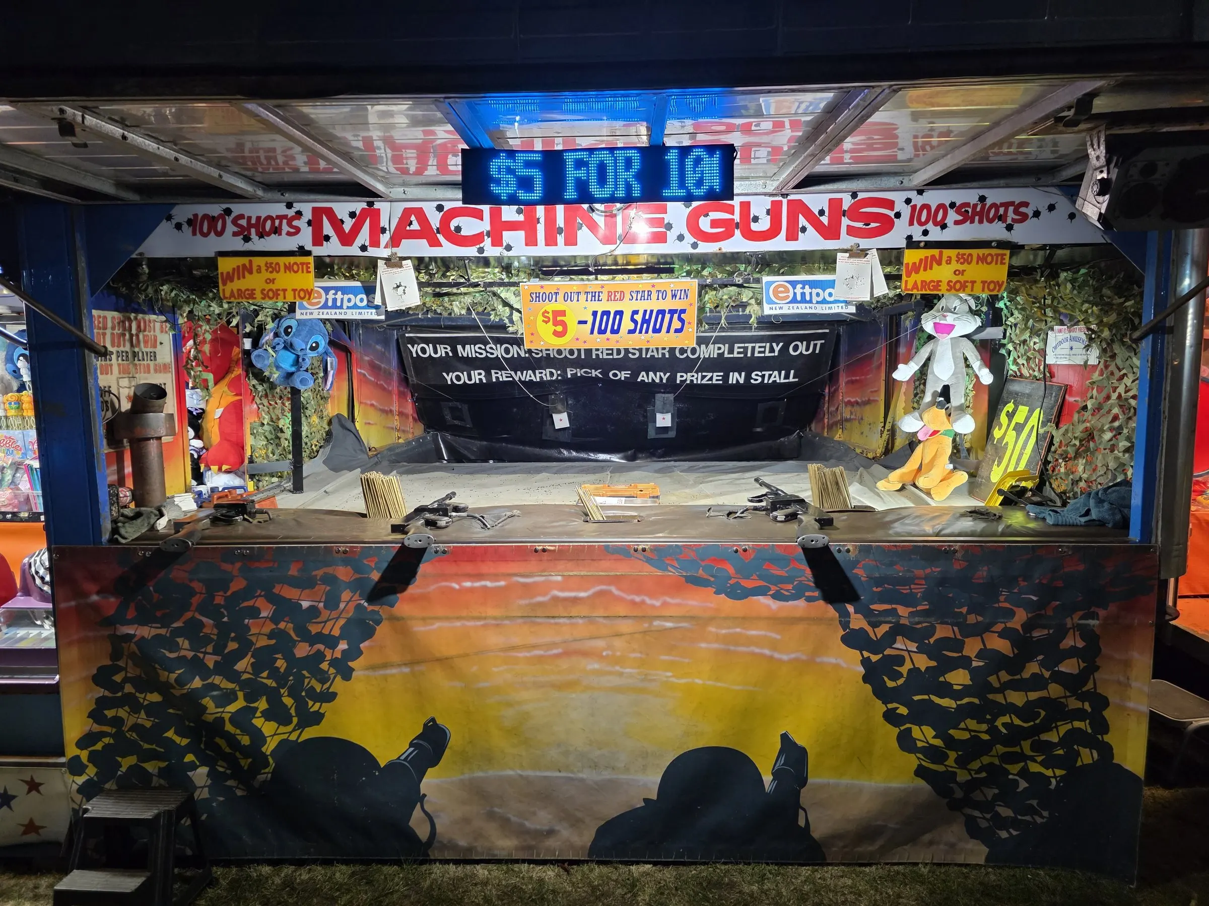 Machine guns shooting stall with a sunset backdrop