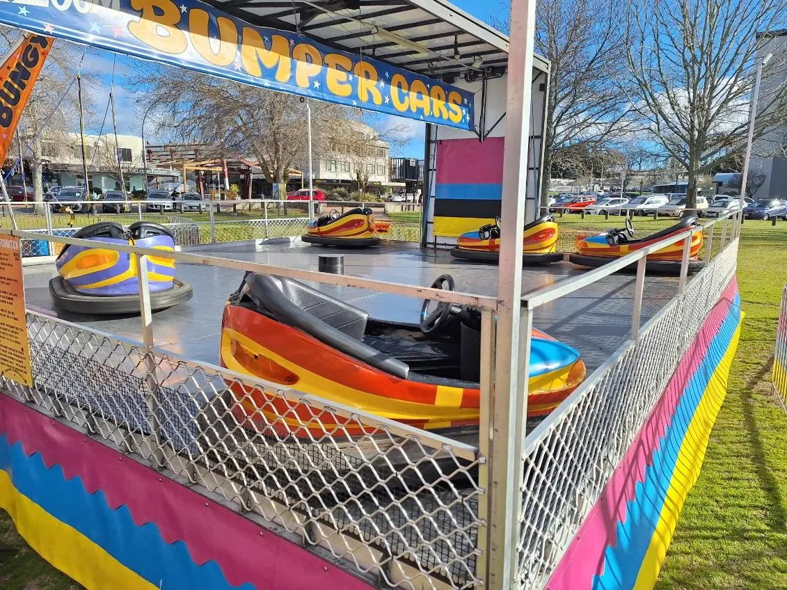 Bumper cars on a striped arena under a blue sky