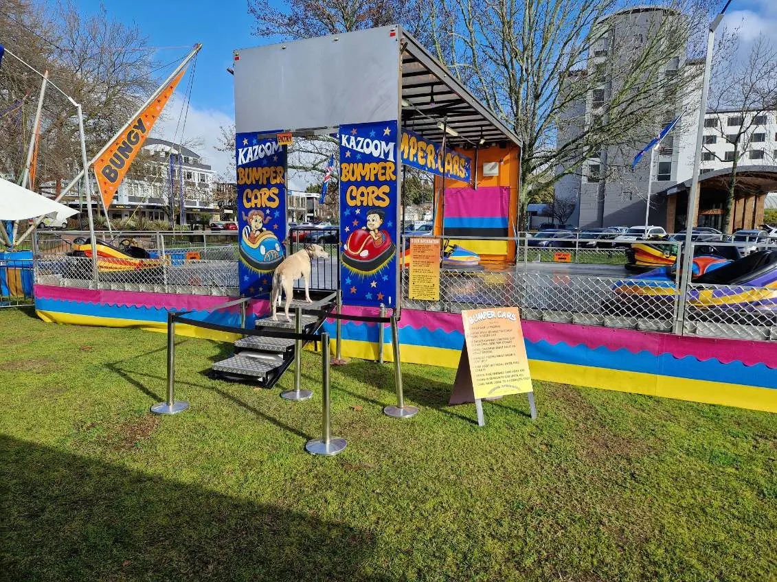 Bumper car arena with Kazoom banners and a striped ramp on the grass